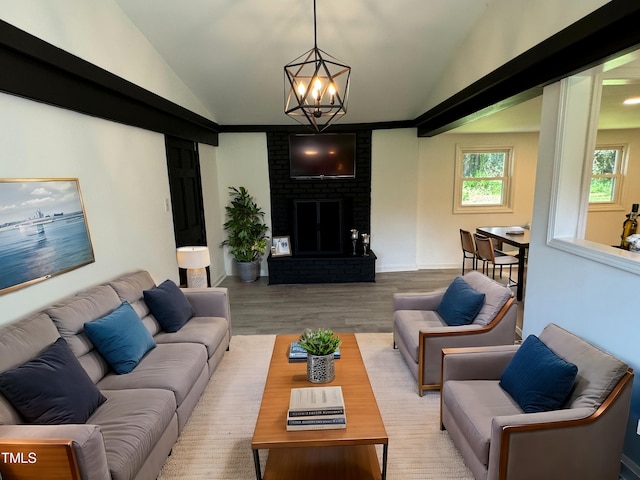 living room with a fireplace, light wood-type flooring, lofted ceiling, and a chandelier