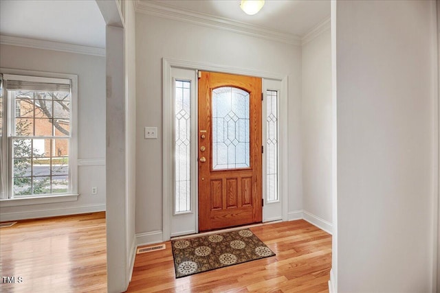 foyer entrance with crown molding and light hardwood / wood-style floors