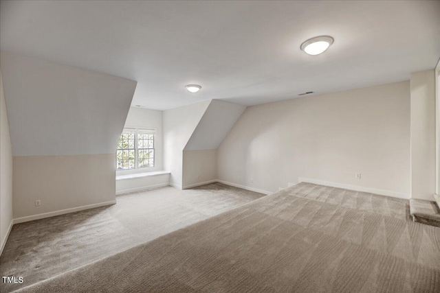 additional living space with vaulted ceiling and light colored carpet