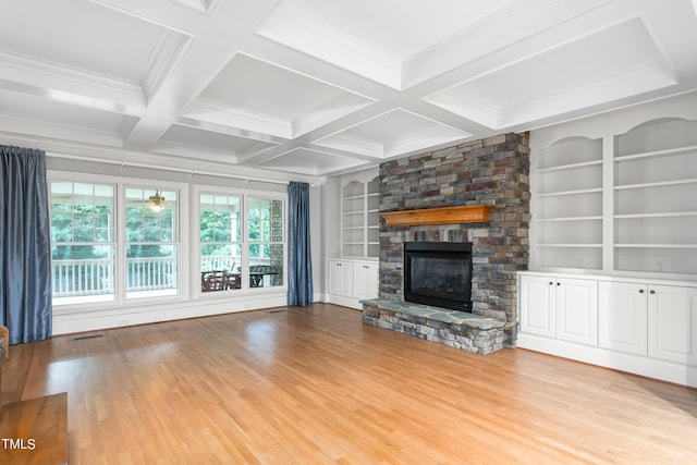 unfurnished living room featuring light hardwood / wood-style floors, built in features, beamed ceiling, and a fireplace