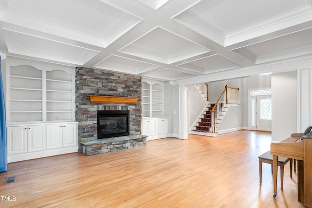 unfurnished living room with built in shelves, beamed ceiling, coffered ceiling, and a fireplace