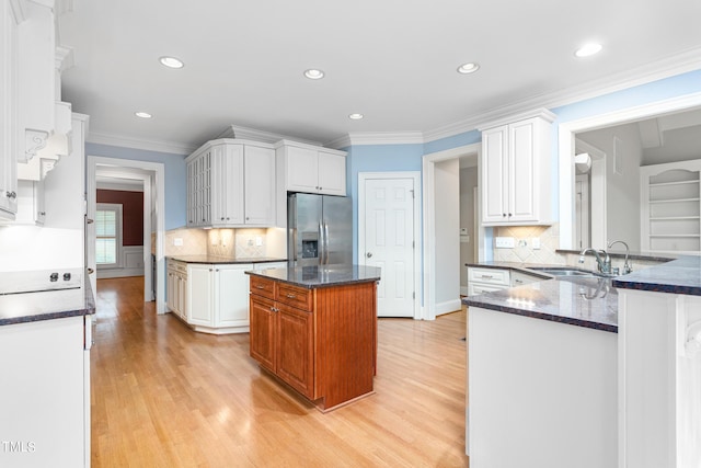 kitchen with kitchen peninsula, sink, white cabinets, stainless steel fridge with ice dispenser, and light hardwood / wood-style floors