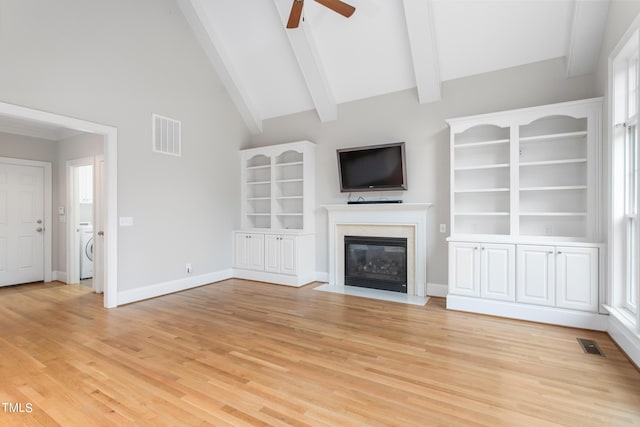 unfurnished living room with ceiling fan, beamed ceiling, a healthy amount of sunlight, and high vaulted ceiling