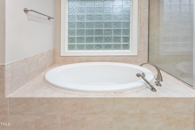 bathroom with a relaxing tiled tub