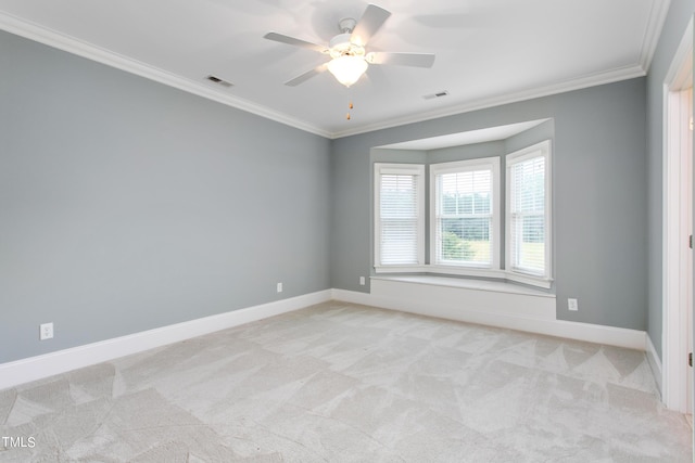 spare room featuring ceiling fan, light carpet, and crown molding