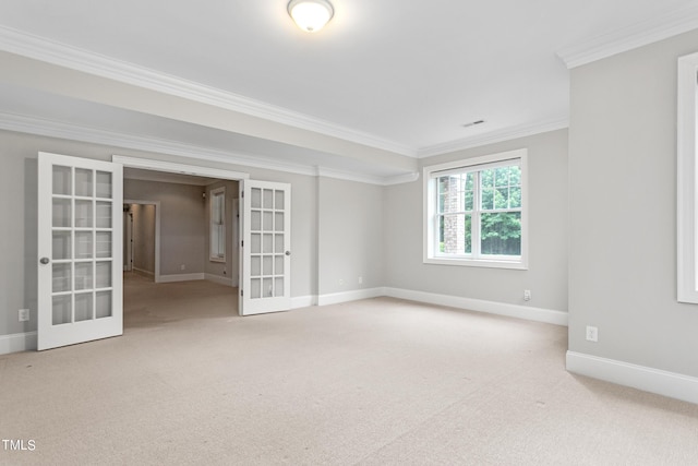 empty room featuring crown molding, light carpet, and french doors