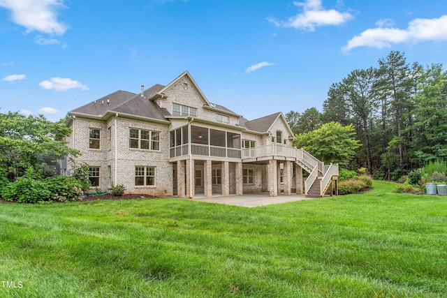 rear view of house featuring a patio area, a lawn, a wooden deck, and a sunroom