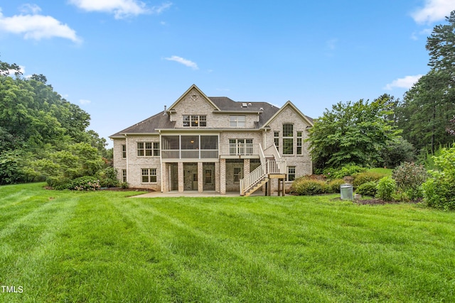 back of house with a wooden deck, a yard, a sunroom, and a patio