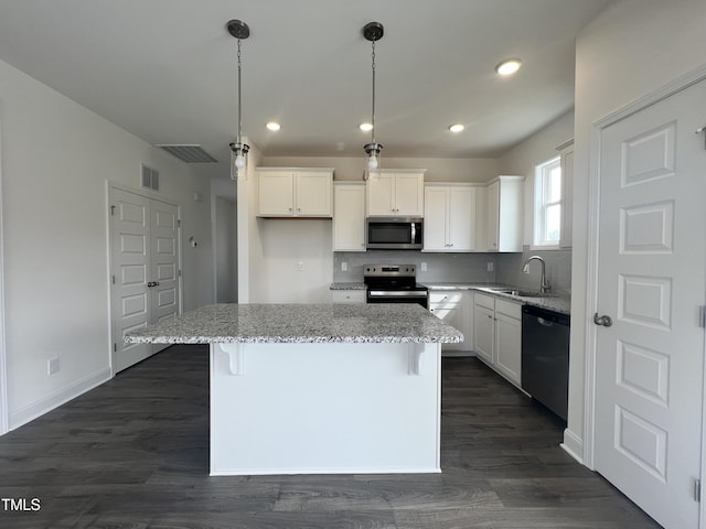 kitchen with a sink, stainless steel appliances, dark wood-type flooring, white cabinetry, and backsplash