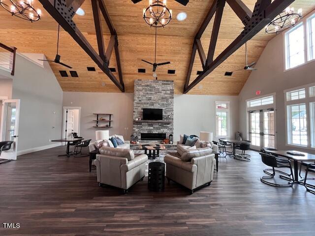 living room featuring wooden ceiling, a fireplace, dark wood-style floors, and a ceiling fan