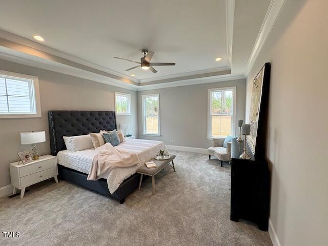 bedroom with ornamental molding, a raised ceiling, light carpet, and baseboards