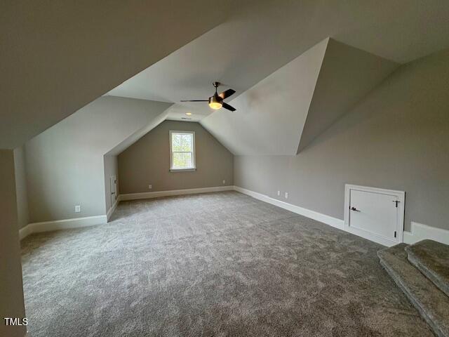 bonus room featuring a ceiling fan, carpet, lofted ceiling, and baseboards