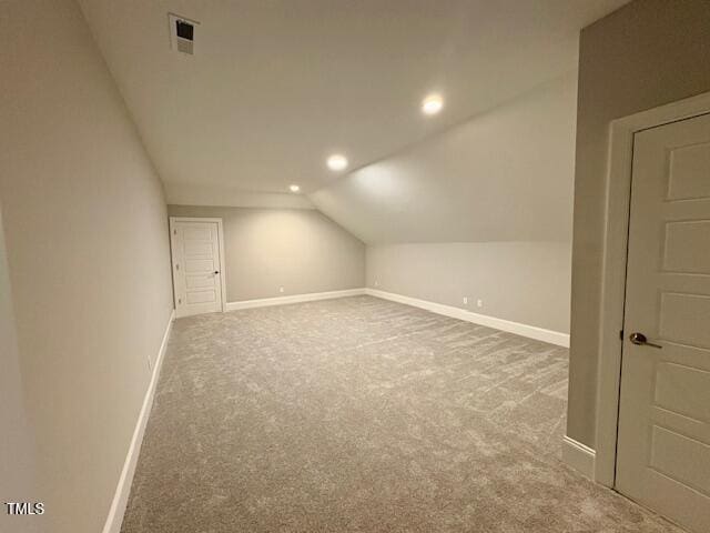 bonus room with vaulted ceiling, carpet floors, visible vents, and baseboards