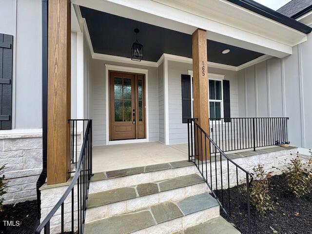 entrance to property featuring covered porch and board and batten siding