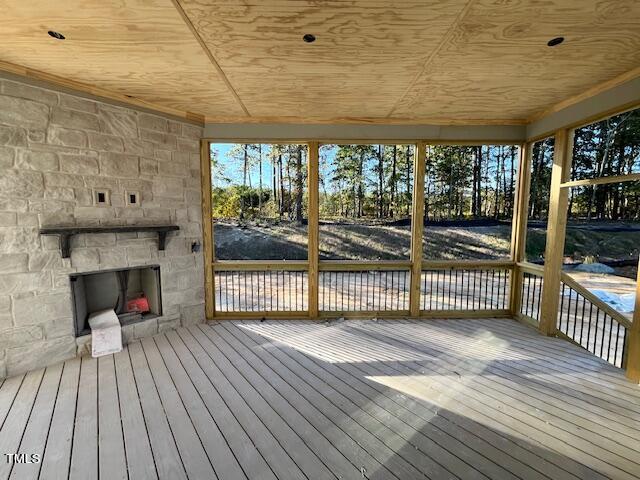 wooden terrace with a stone fireplace