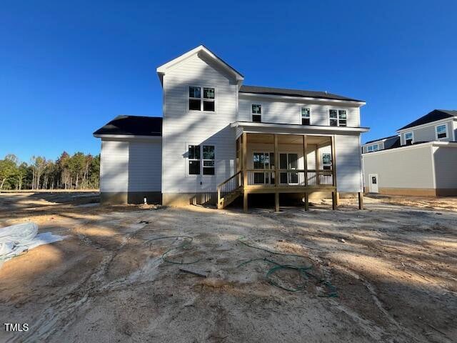 rear view of property featuring a sunroom