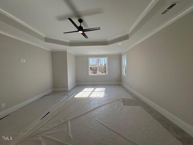 unfurnished room featuring crown molding and a tray ceiling