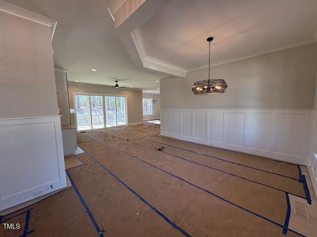 unfurnished dining area featuring ceiling fan with notable chandelier