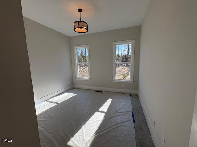 spare room featuring dark colored carpet