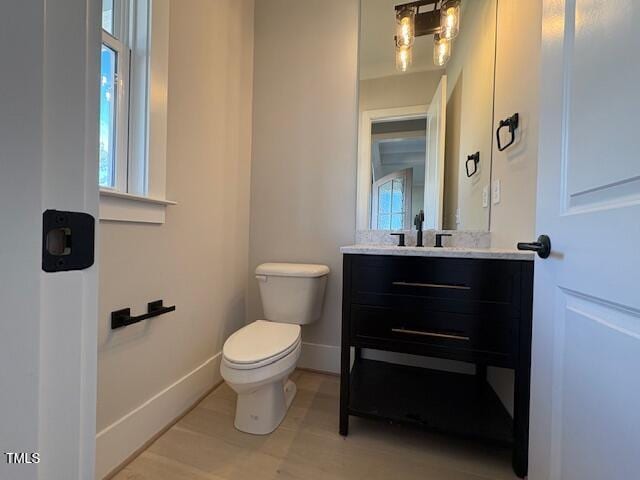 bathroom featuring vanity, wood-type flooring, and toilet