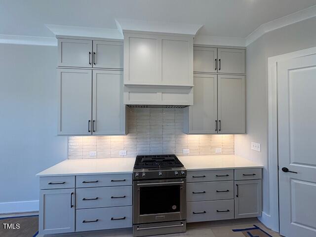 kitchen featuring crown molding, gas stove, and decorative backsplash