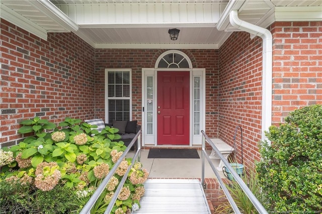 doorway to property with brick siding