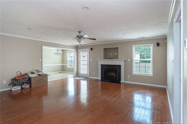 unfurnished living room with baseboards, ornamental molding, a fireplace, wood finished floors, and a textured ceiling