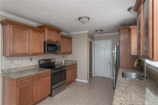 kitchen featuring sink, light stone counters, stainless steel appliances, and light tile patterned floors