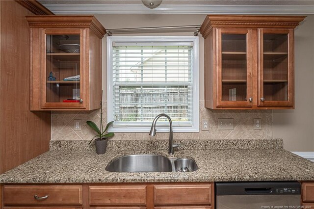 kitchen with sink, stainless steel dishwasher, decorative backsplash, and light stone counters