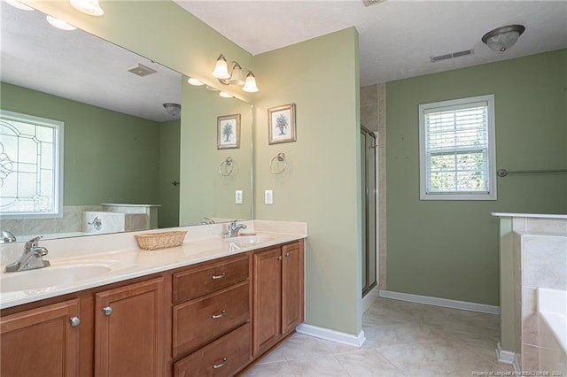 bathroom featuring visible vents, a garden tub, and a sink