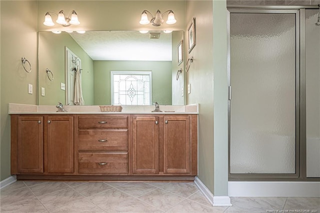 bathroom with a shower with shower door, tile patterned flooring, and dual bowl vanity