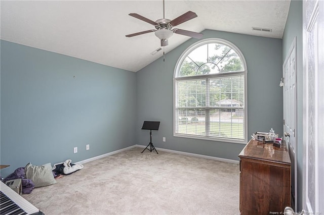 interior space featuring lofted ceiling, multiple windows, baseboards, and visible vents