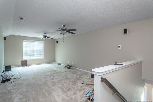 carpeted empty room with a textured ceiling and ceiling fan