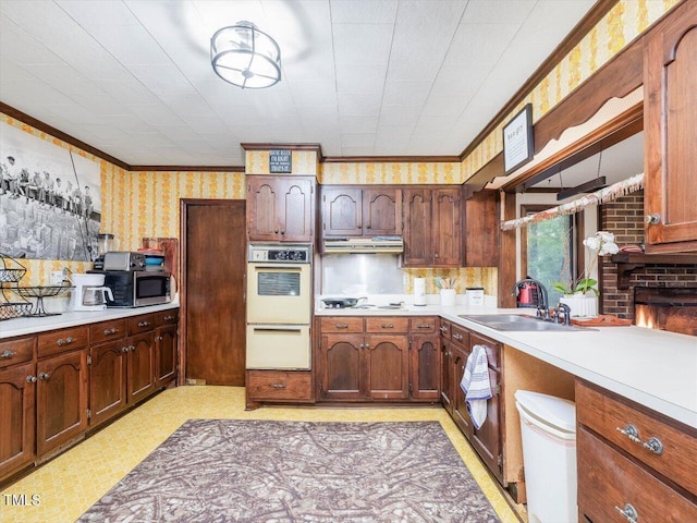 kitchen with crown molding, sink, and wall oven