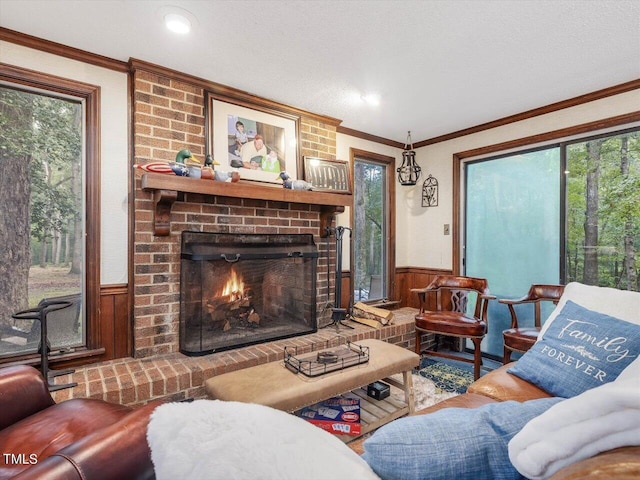 living room featuring ornamental molding, a brick fireplace, and a textured ceiling