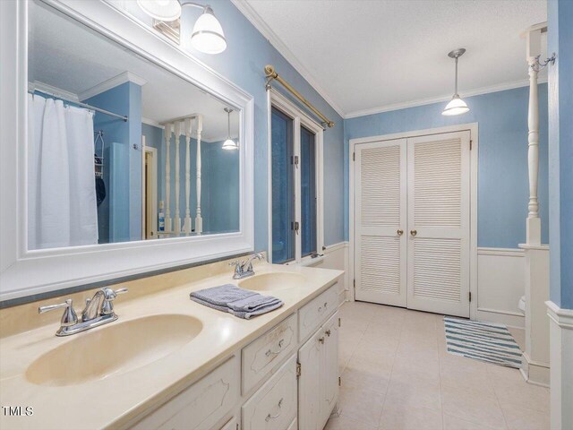 bathroom featuring double vanity, crown molding, and tile patterned flooring