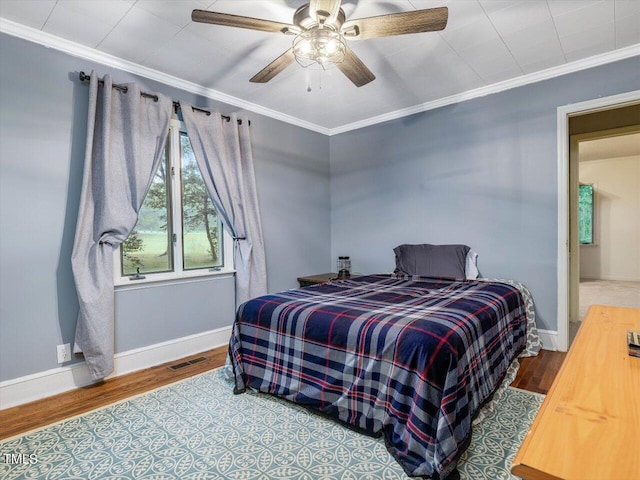 bedroom with crown molding, wood-type flooring, and ceiling fan