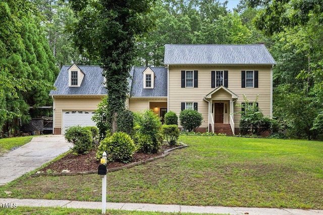 colonial inspired home with a garage and a front yard