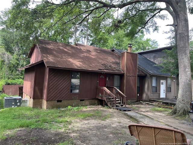 view of front facade with crawl space, central AC, a chimney, and roof with shingles