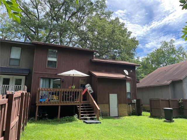 rear view of house with a deck and a lawn