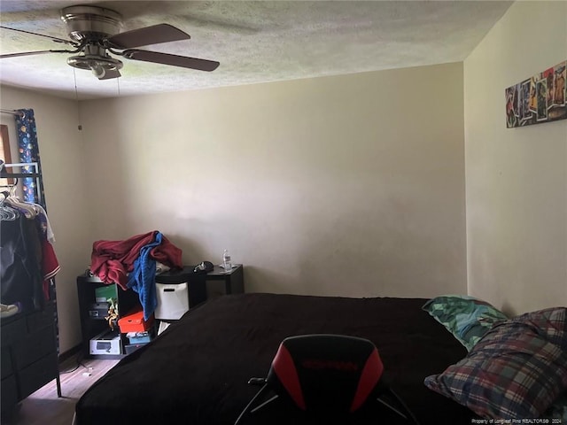 bedroom featuring ceiling fan and a textured ceiling