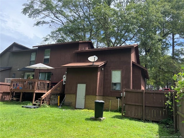 back of house with a yard, a wooden deck, and fence