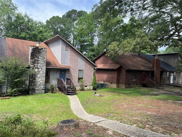 view of front of property featuring an outdoor fire pit, central AC unit, a chimney, crawl space, and a front lawn