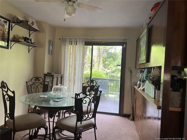 dining space featuring a ceiling fan and light carpet