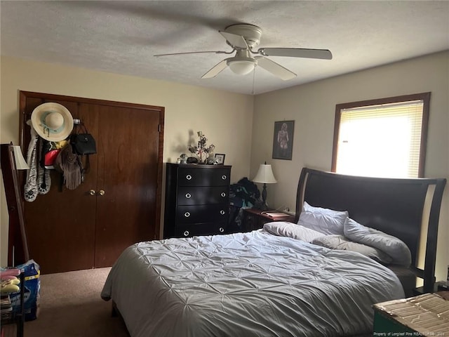 carpeted bedroom featuring a textured ceiling, a closet, and a ceiling fan