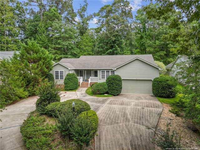 single story home with a garage, driveway, and roof with shingles