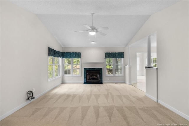 unfurnished living room featuring baseboards, light colored carpet, vaulted ceiling, and ceiling fan