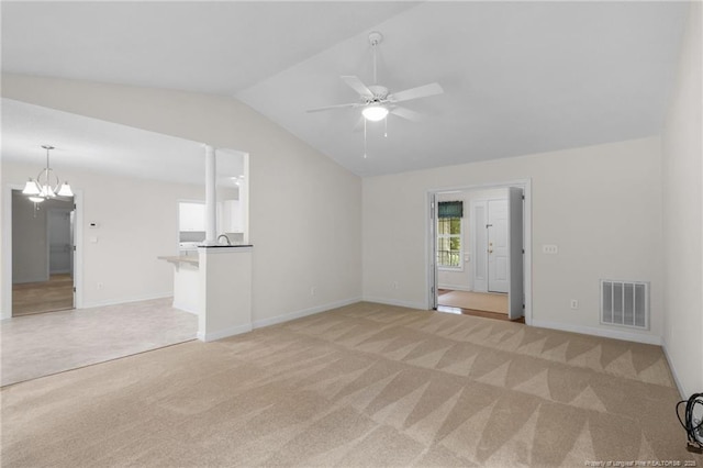 unfurnished living room featuring baseboards, visible vents, lofted ceiling, light colored carpet, and ceiling fan with notable chandelier