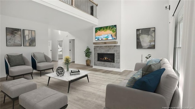 living room featuring a towering ceiling, a wealth of natural light, and light hardwood / wood-style flooring