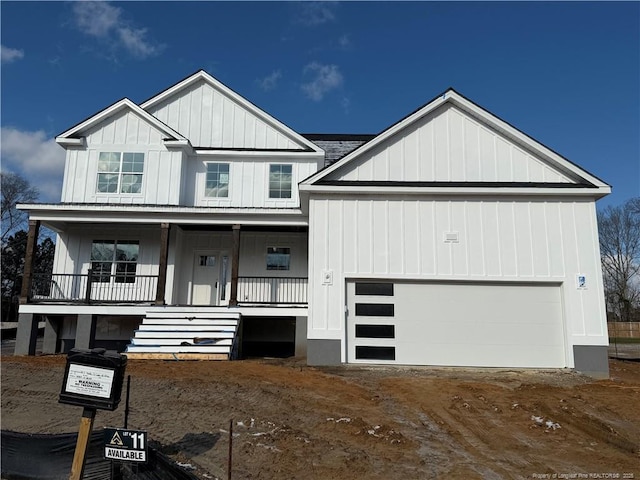 modern farmhouse style home with a garage, driveway, a porch, and board and batten siding